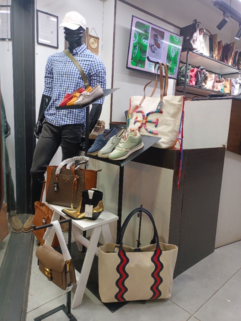 Styled mannequin with sneakers and bags at Masees Ambur